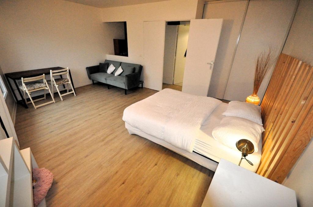 une chambre avec un grand lit blanc et un canapé dans l'établissement Nice 36 m2 - Parc des Buttes Chaumont!, à Paris