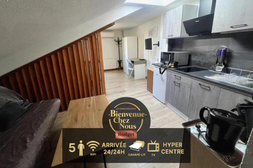 - une cuisine avec une table et un panneau pour un réfrigérateur dans l'établissement Montferrand Dortoir, à Clermont-Ferrand