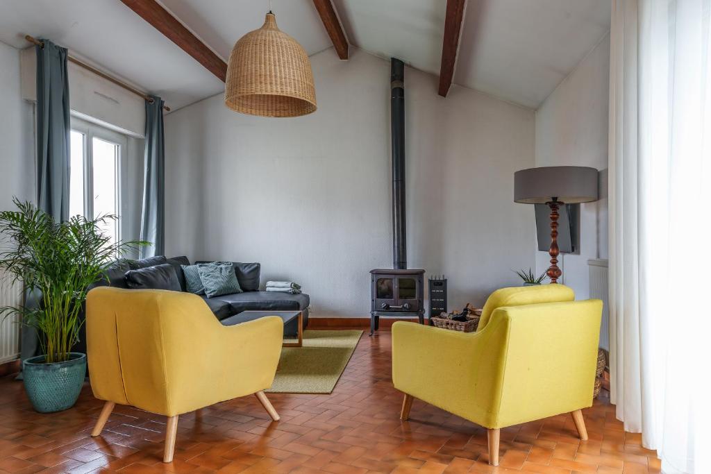 ein Wohnzimmer mit zwei gelben Stühlen und einer Couch in der Unterkunft Maison familiale jardin terrasse proche lac Joué in Joue-les-Tours