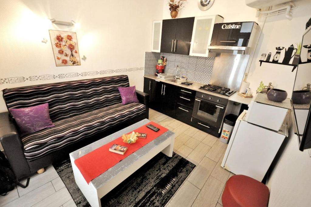 - une cuisine avec un canapé et une table dans une chambre dans l'établissement Warm and comfortable studio in Montmartre, à Paris