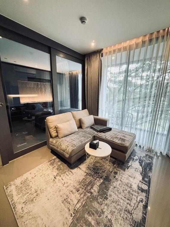 a living room with a couch and a table at Citygate Kamala Condo Paris in Kamala Beach