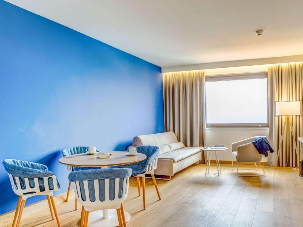 a living room with a couch and a table at Novotel Gdańsk Marina in Gdańsk