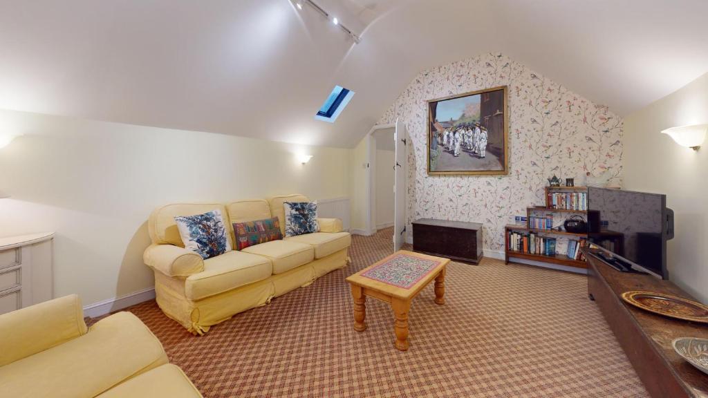 ein Wohnzimmer mit Sofa und Fernseher in der Unterkunft Hannah Cottage in Adderbury