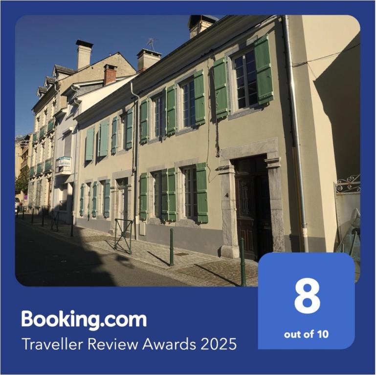 a building with green shutters on a street at Maison au coeur d'Argelès in Argelès-Gazost