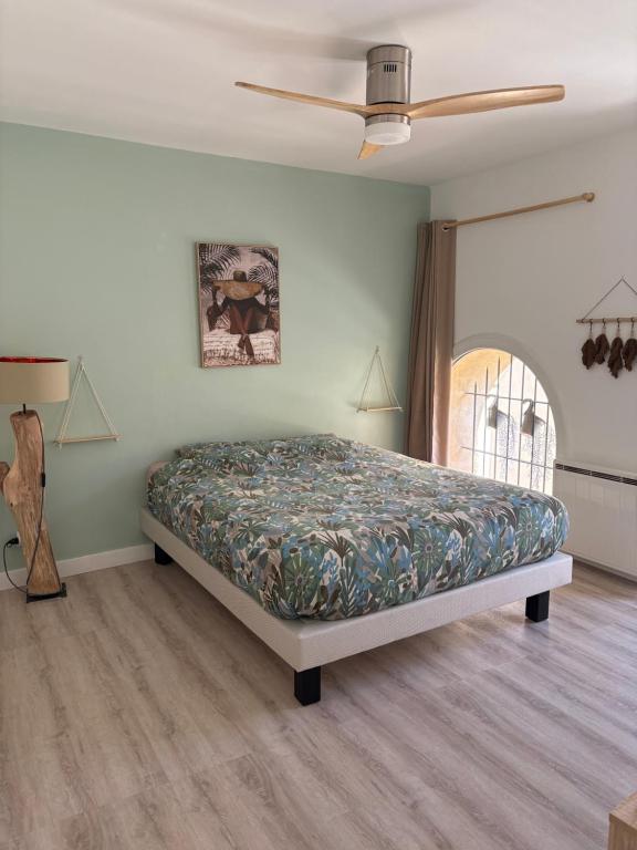 une chambre avec un lit et un ventilateur de plafond dans l'établissement Séjour paisible en Provence, à Lambesc
