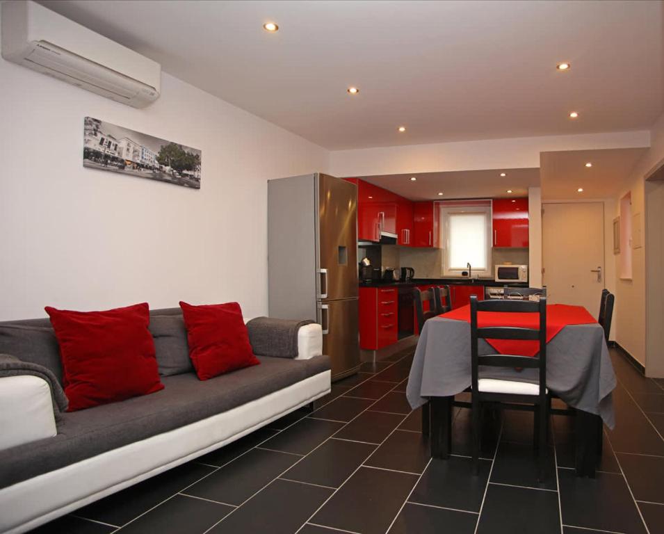un soggiorno con divano e tavolo con cuscini rossi di Apartment Aiko - Downtown Albufeira ad Albufeira