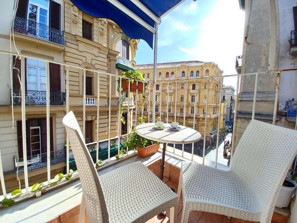 ein Balkon mit zwei Stühlen und einem Tisch auf einem Balkon in der Unterkunft B&B Quattro Palazzi Napoli Centro in Neapel