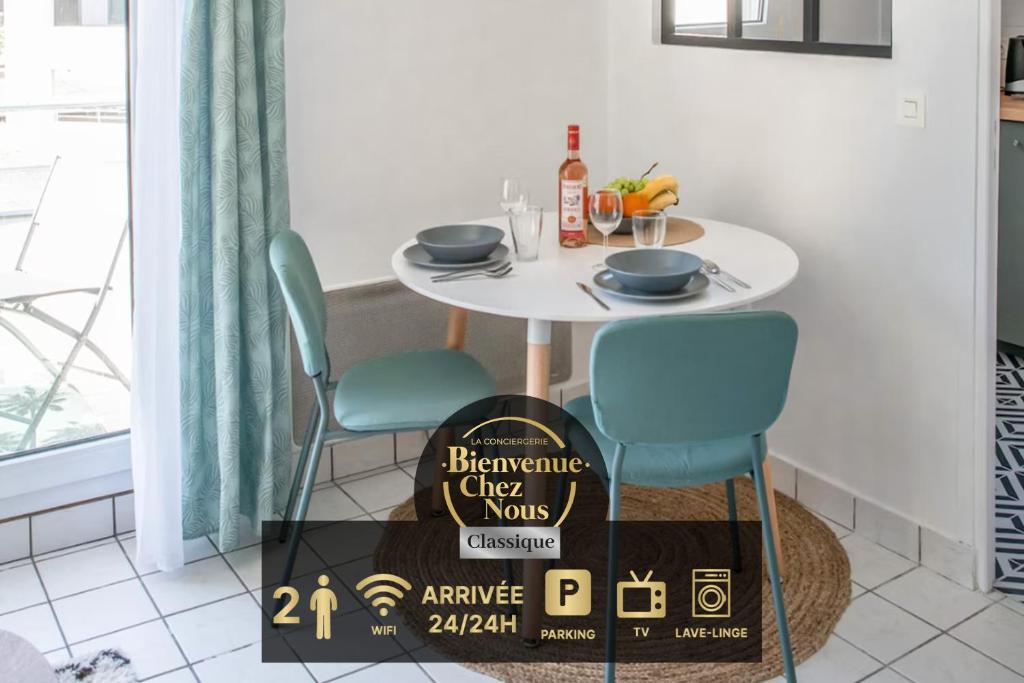 einen Tisch mit 2 Stühlen und ein Schild in der Küche in der Unterkunft L'Amadéo - T2 Centre-ville & Parking in Clermont-Ferrand