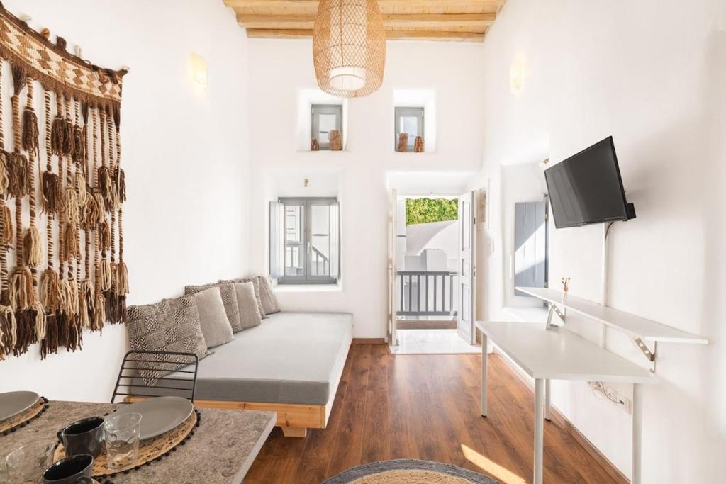 a white living room with a couch and a table at Cove in Mýkonos City
