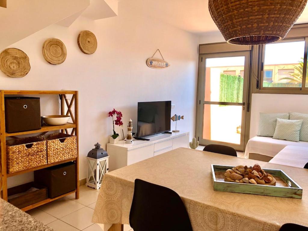 a living room with a table and a television at Aire de Oceano in Costa de Antigua