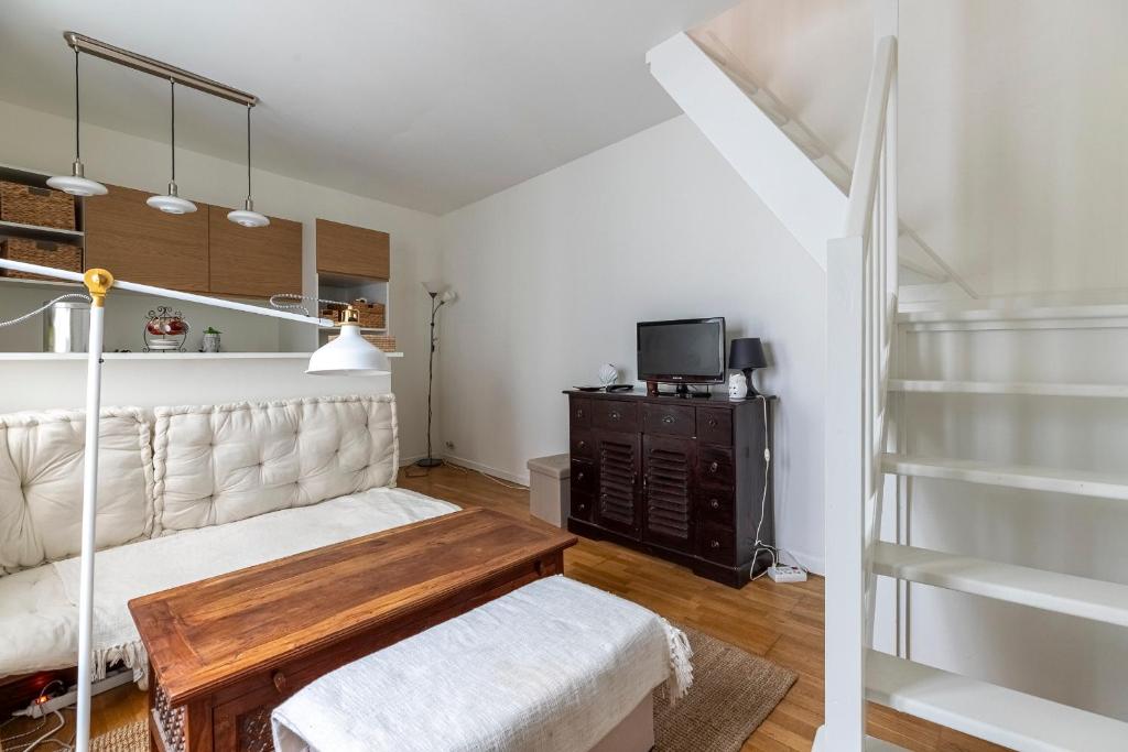 un salon avec un canapé et une télévision dans l'établissement Le Mont - Super appartement au coeur de Paris, à Paris