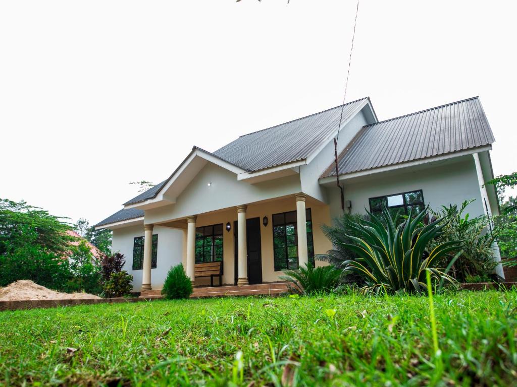 ein Haus mit einem grünen Rasen davor in der Unterkunft Karibu Cottage Safari in Nkunjila