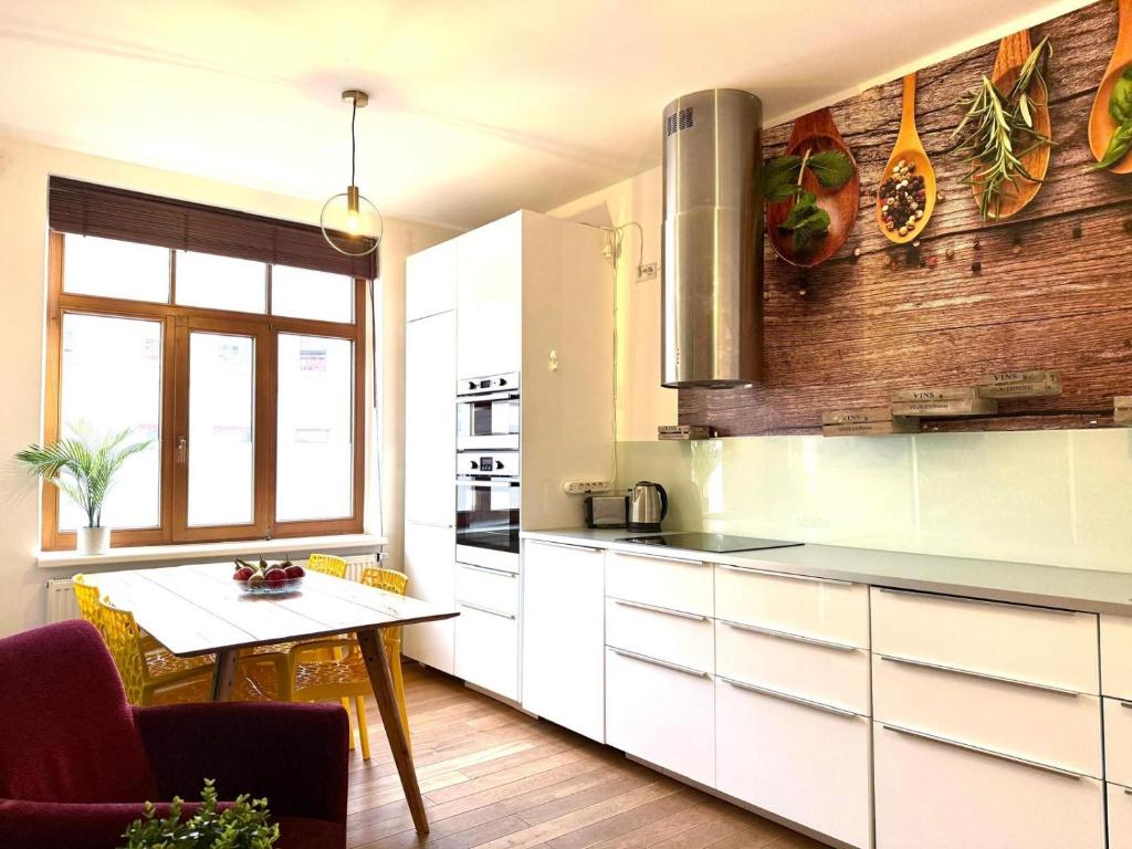 a kitchen with white cabinets and a table in it at Linden-Charm Apartments in Hannover