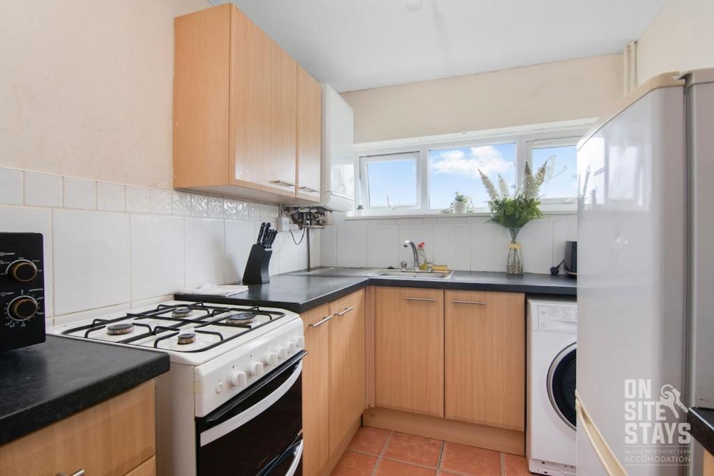 a kitchen with wooden cabinets and a stove top oven at Contractors 4 Bed with Parking in Hatfield