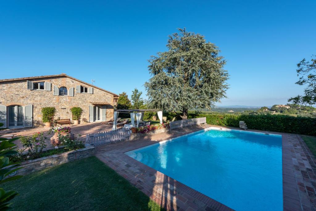 a large swimming pool in front of a house at Villa Porri by MMega in Siena