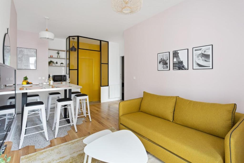 un salon avec un canapé jaune et une cuisine dans l'établissement Pink Design 2BDR Flat in the Heart of Bastille, à Paris