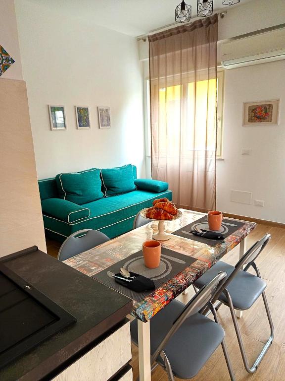 a living room with a table and a blue couch at Studio 49 - da Frank in Giardini Naxos