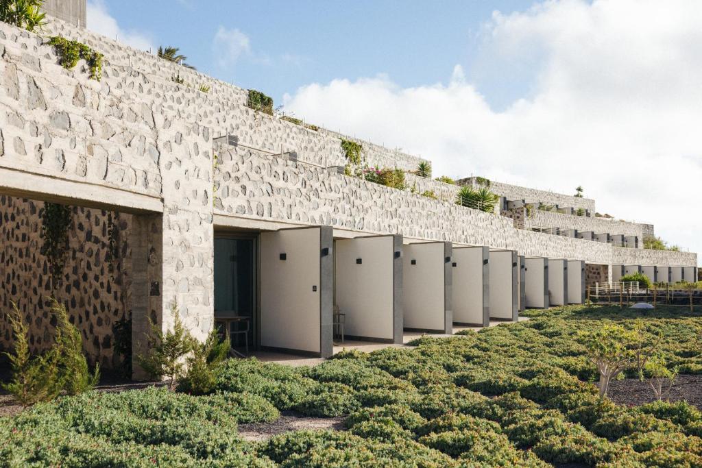 a row of white toilets on a brick wall at BANCAL HOTEL and SPA in San Sebastián de la Gomera