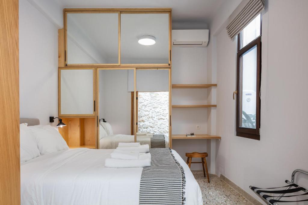 a bedroom with a bed with towels on it at Chryssi 02, Comfort & Style, Centrally in Rethymno, close to the beach in Rethymno Town