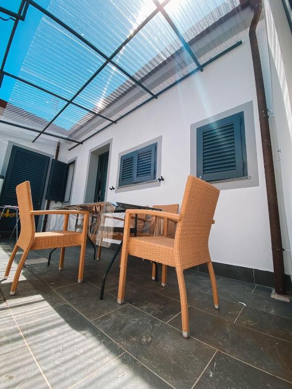 a patio with two chairs and a table and windows at Casina Viareggina 2 camere in Viareggio