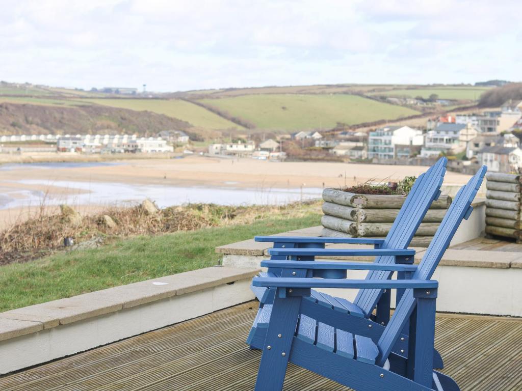 einen blauen Schaukelstuhl auf einer Veranda mit Blick auf den Strand in der Unterkunft Catch the Wave in Newquay