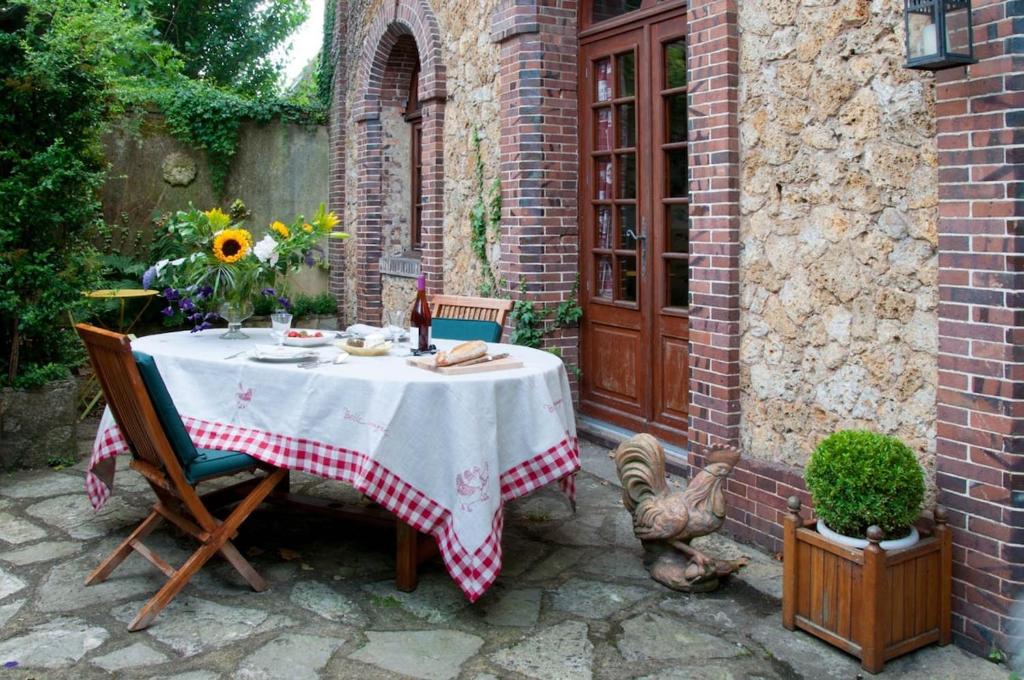 - une table avec une composition florale sur la terrasse dans l'établissement Sweet country home in Normandy, à Verneuil-sur-Avre