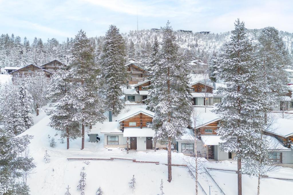 an apartment building covered in snow with trees at Lilla Köngäs, 2 skipasses RUKA-PYHÄ included, Skibus doorstep in Ruka