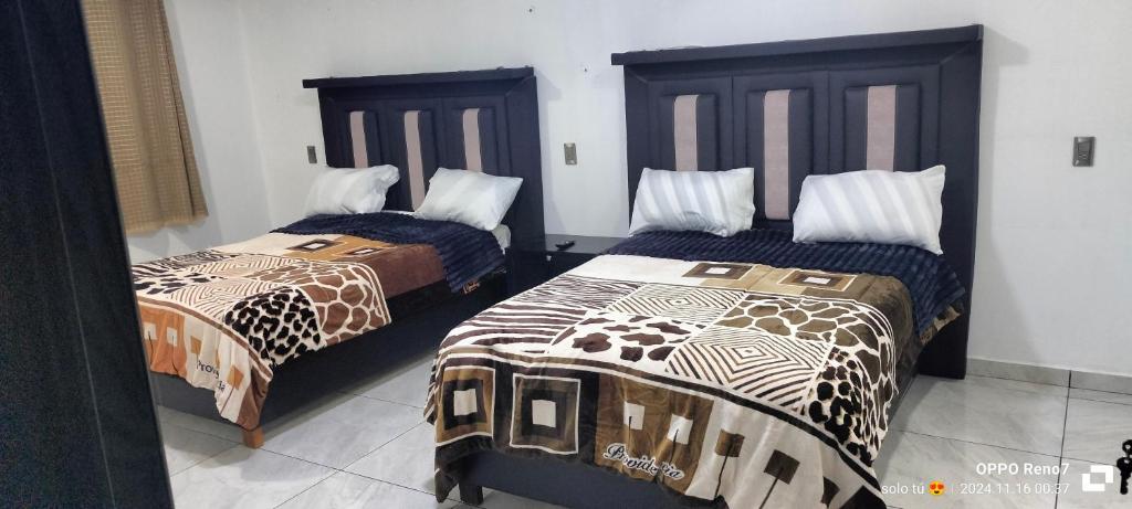 チグナワパンにあるHabitaciones Cruz Condeの部屋に並んで置かれた2つのベッド