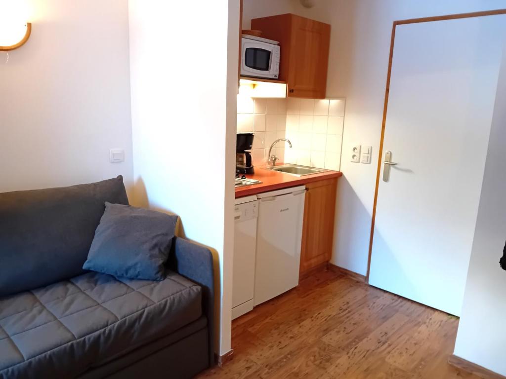 un salon avec un canapé et une cuisine dans l'établissement Terrasses D 103 - PARC NAT VANOISE studio 2 pers, à Val Cenis