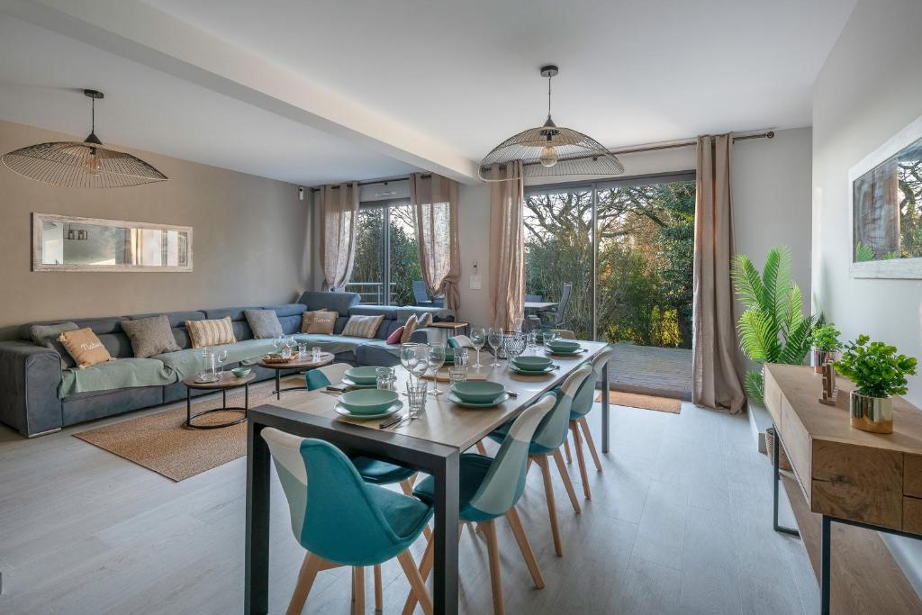 une salle à manger et un salon avec une table et des chaises dans l'établissement Maison moderne avec jardin pour 8 - La Baule, à La Baule