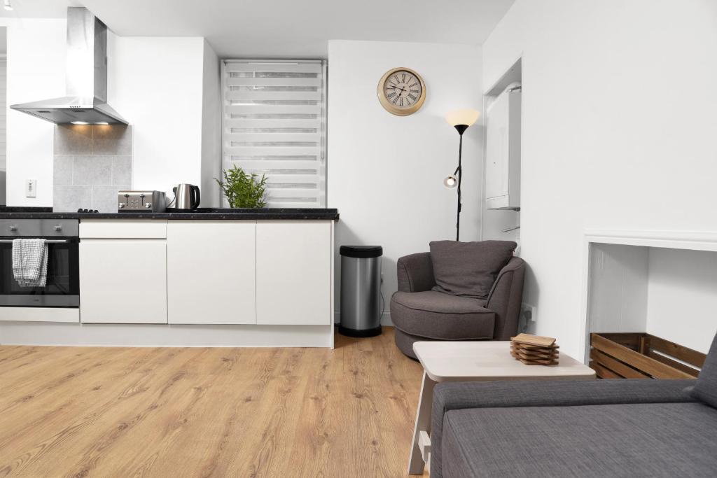 a kitchen and living room with a couch and a chair at Central Baxter Park Apt ! Free WiFi ! Sleeps 6 in Dundee