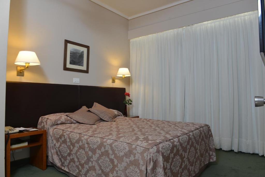a hotel room with a bed and a window at Comodoro Hotel in Comodoro Rivadavia
