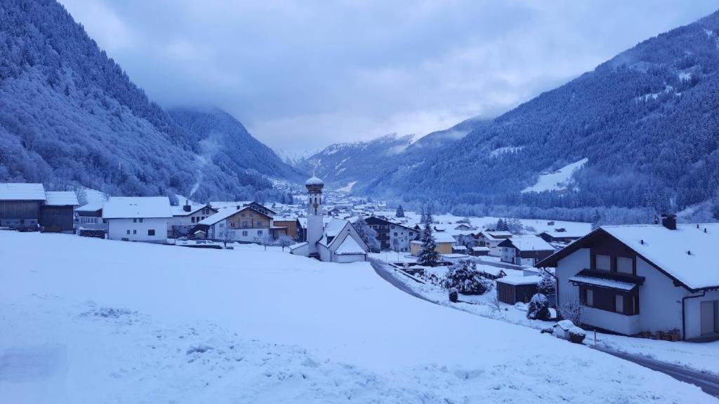 a town covered in snow with mountains in the background at Montafon Valley Rooms in Sankt Gallenkirch