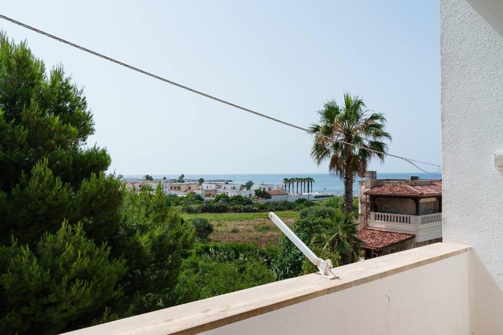 a view from the balcony of a house with a palm tree at Vista Mare Paradiso by Salento Prime in Torre Vado