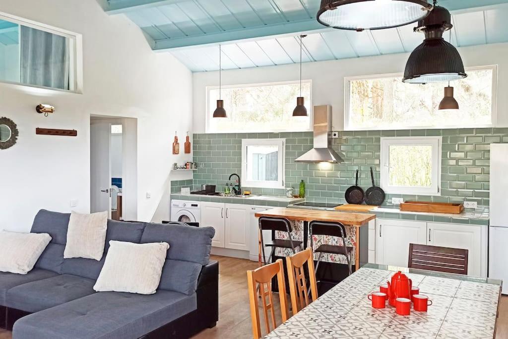 a living room with a blue couch and a kitchen at El Pinsapo in Segovia