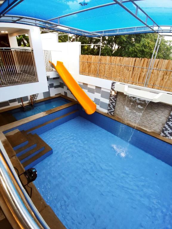 a pool with a slide in the middle of a house at CASA BENITO Private Hot Spring Resort in Los Baños