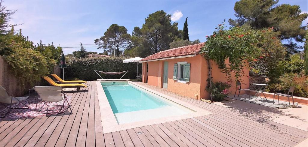 a house with a swimming pool on a wooden deck at La Maisonnette de vacances avec piscine privée pour 2 pers in Lorgues