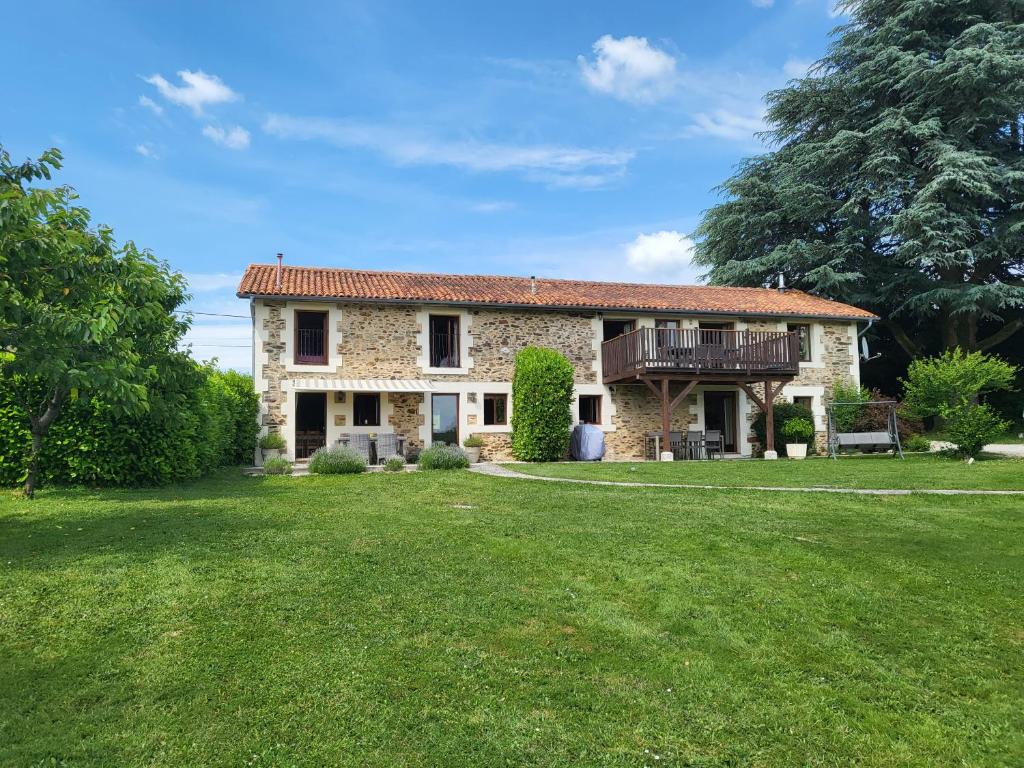 Cette maison en pierre dispose d'un balcon et d'une cour. dans l'établissement Gites at Le Tilleul - Le Pommier & Le Cerisier, à Le Lindois