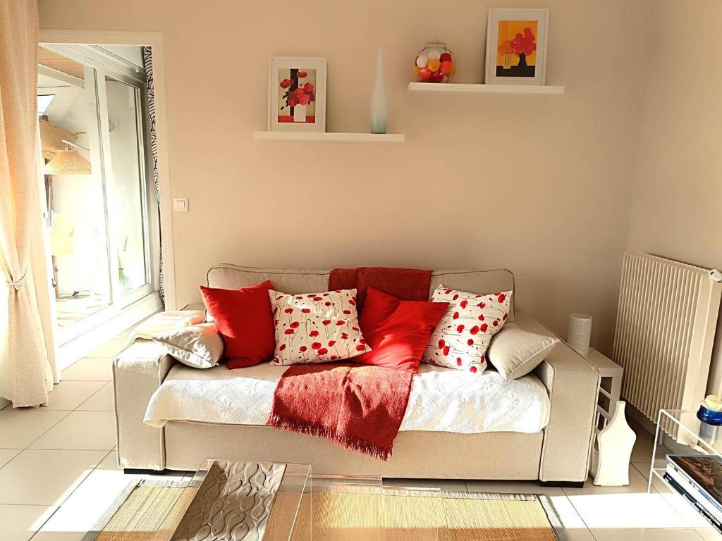 - un salon avec un canapé et des oreillers rouges dans l'établissement Bel appartement avec parking WIFI au centre-ville de PERROS-GUIREC - Réf 938, à Perros-Guirec