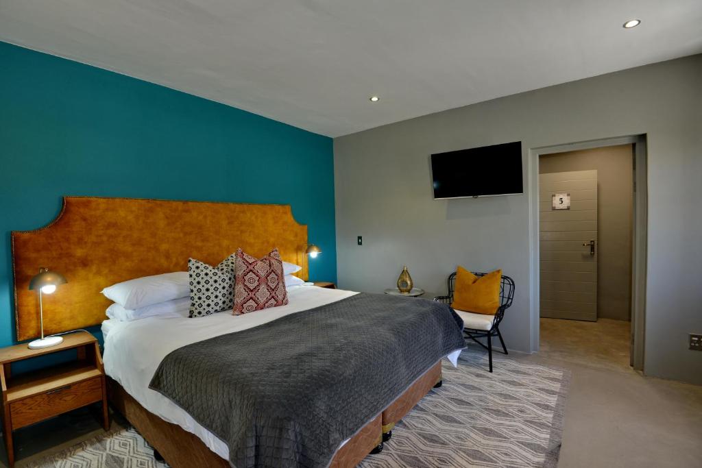 a bedroom with a large bed and a flat screen tv at Belle Maroc Boutique Hotel in Bloubergstrand