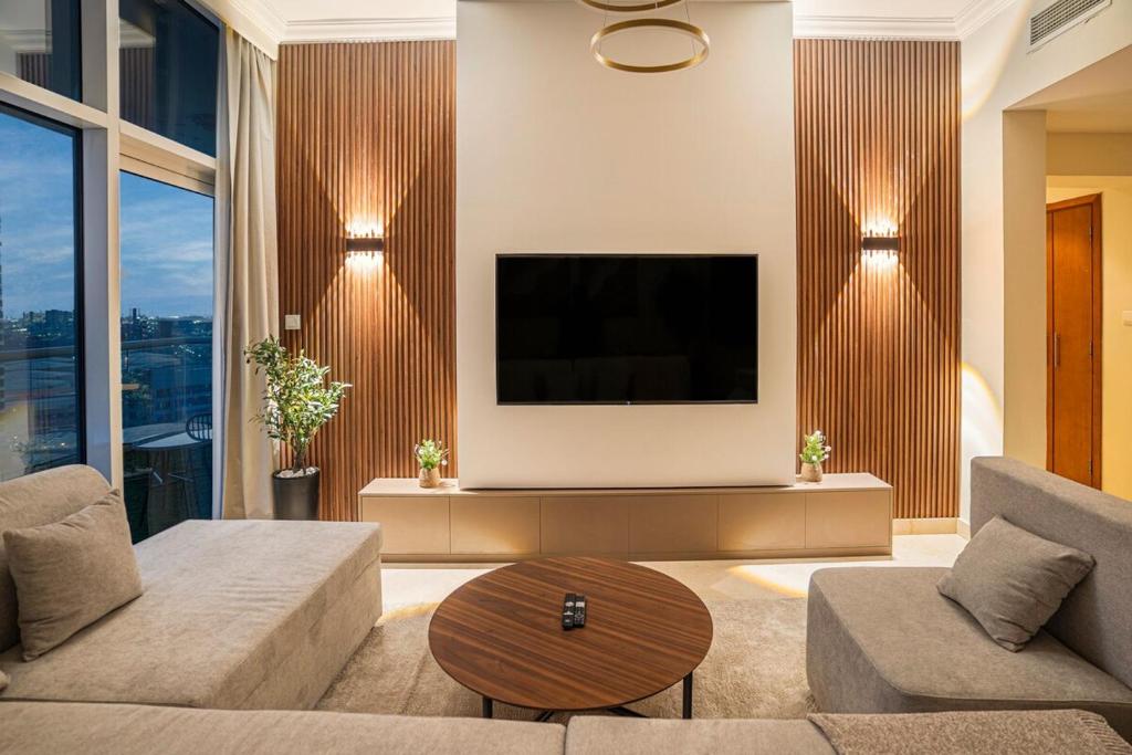 ドバイにある13 - Stylish Palm view Family Apartment in Dorra Bay - Beach Accessのソファと薄型テレビのあるリビングルーム