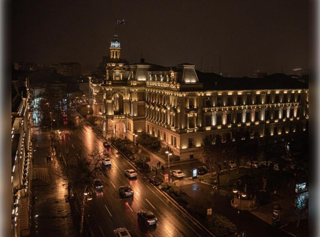 - une vue sur une ville la nuit avec un bâtiment dans l'établissement Liman Hotel, à Baku