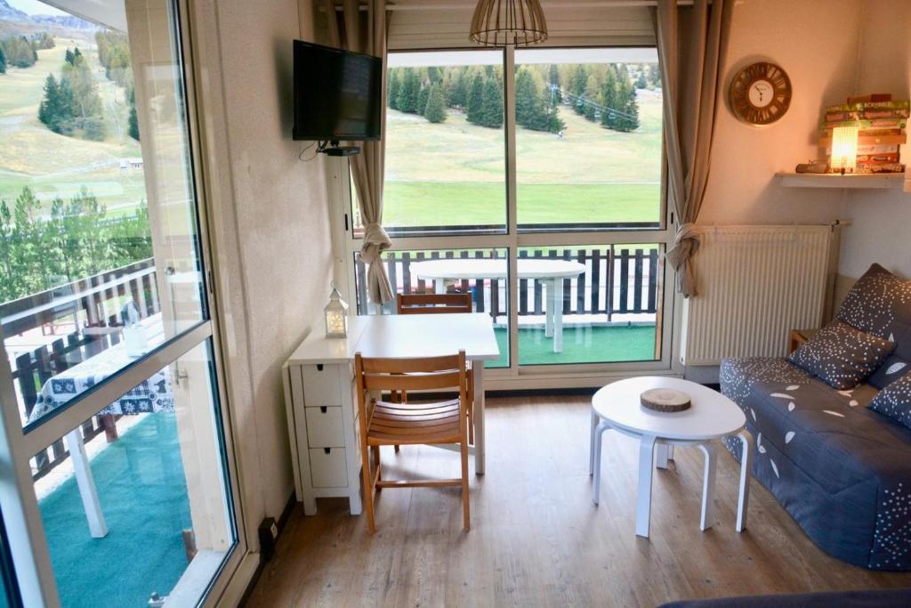 un salon avec un canapé et une table dans l'établissement Le studio de Camille, à Saint-Étienne-en-Dévoluy