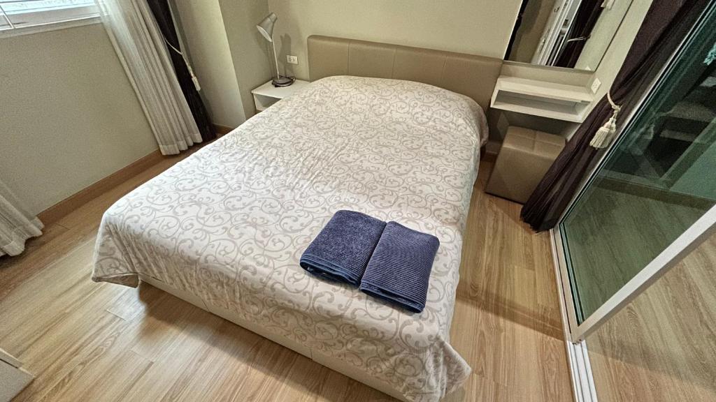 a bedroom with a bed with a blue towel on it at Peaceful Stay at MT Khlong Luang Self-Check-in in Khlong Luang