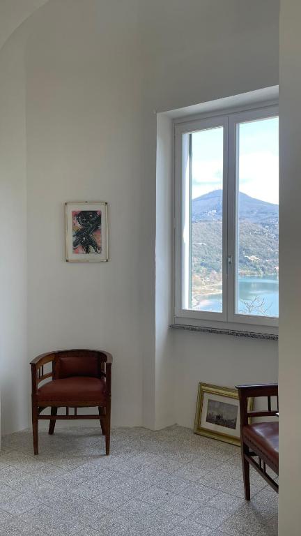 Pokój z krzesłem i oknem z widokiem w obiekcie Domus Lago Rome w mieście Castel Gandolfo