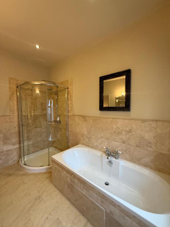 a large bathroom with a tub and a shower at The Old Hunting Lodge at The Talbot Inn in Tenbury