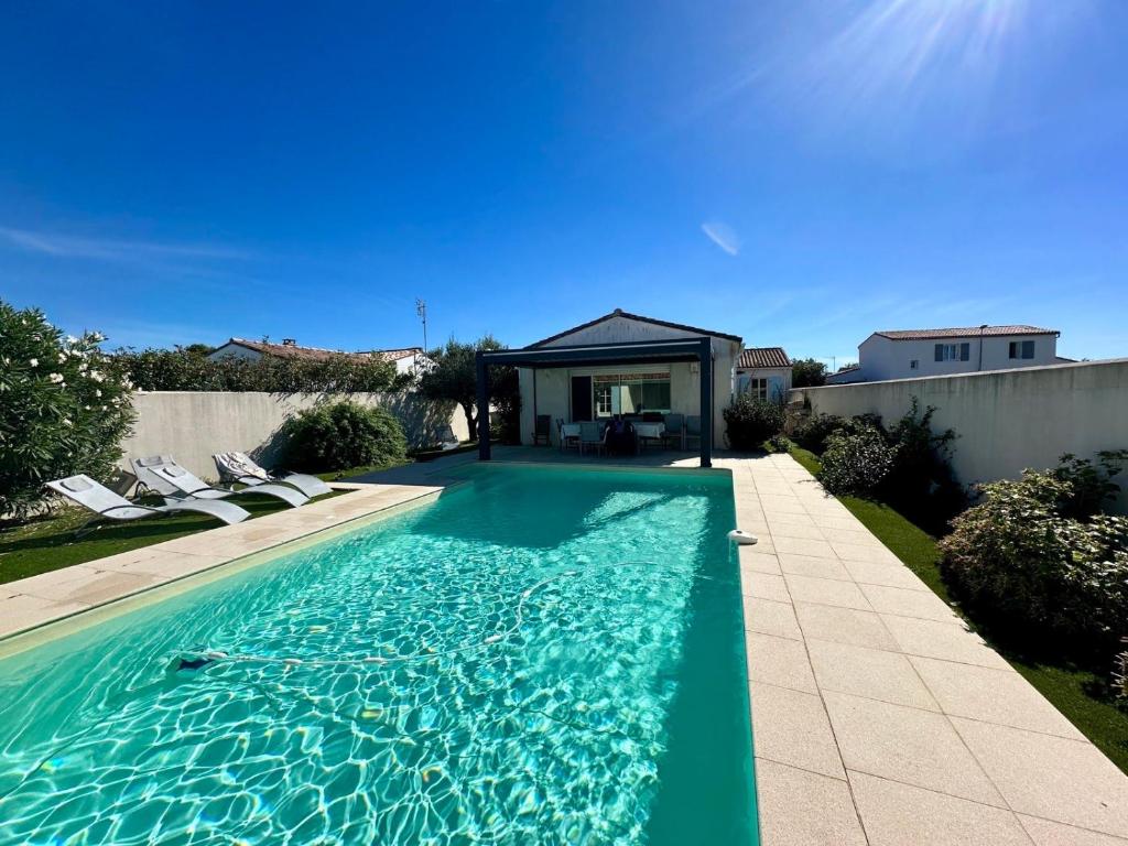 ein Swimmingpool im Hinterhof eines Hauses in der Unterkunft Villa Coraly - piscine chauffée et jardin in Sainte-Marie-de-Ré