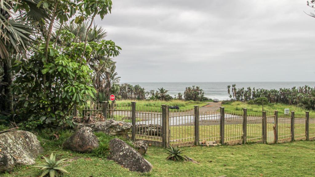 a fence in front of a beach with the ocean at Kimachi in Margate