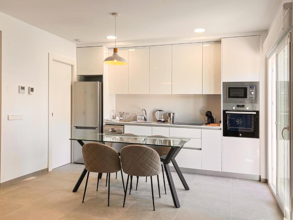 a kitchen with a glass table and two chairs at Casa del Rayo de Sol in San Pedro del Pinatar