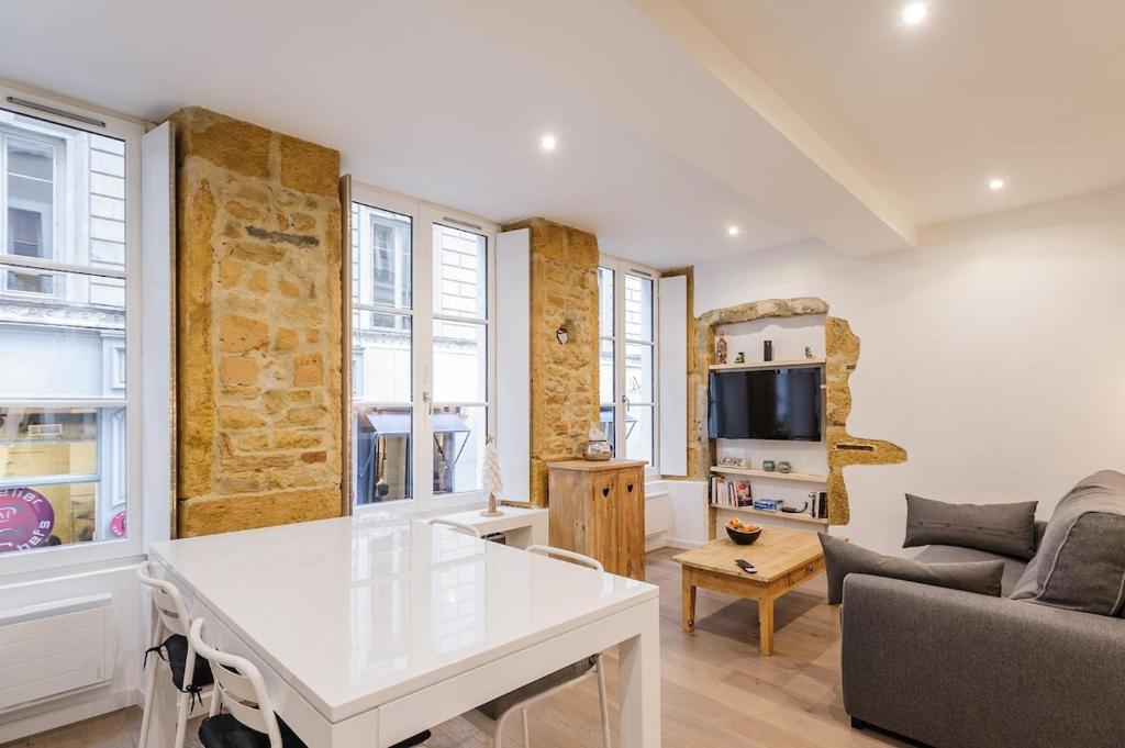 un salon avec une table blanche et un canapé dans l'établissement Le Cocon de Cordeliers, à Lyon